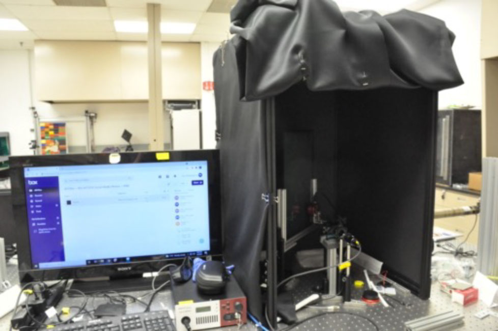 Inside this box, a mounted camera and single light source, a laser, allows Hao to take detailed images of the holograms. The black curtains block out extra light.