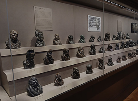 Museum case containing numerous bronze busts of French political figures